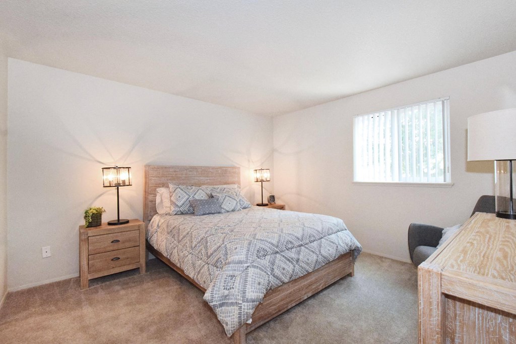 a bedroom with a bed and two lamps