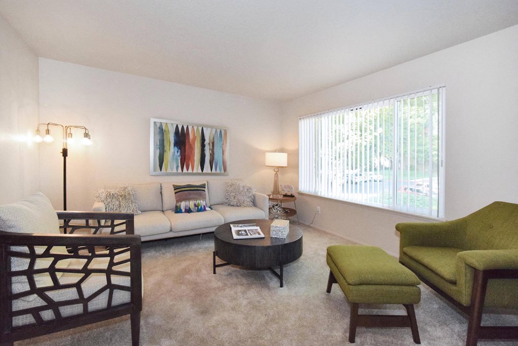 a living room with white walls and a large window