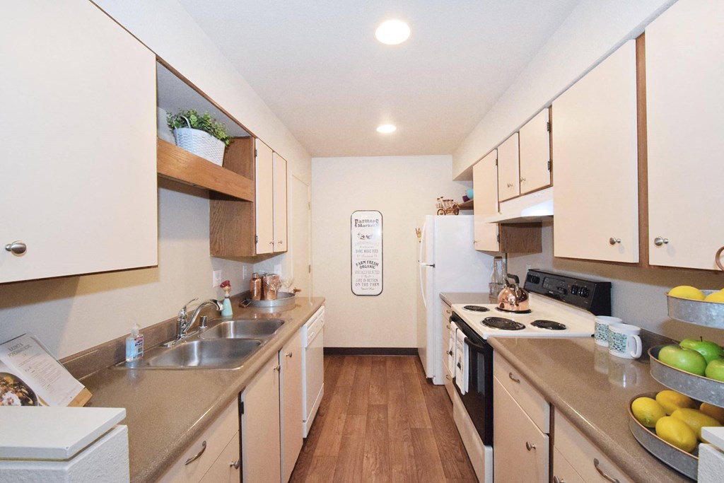 a kitchen with white cabinets and a wooden floor