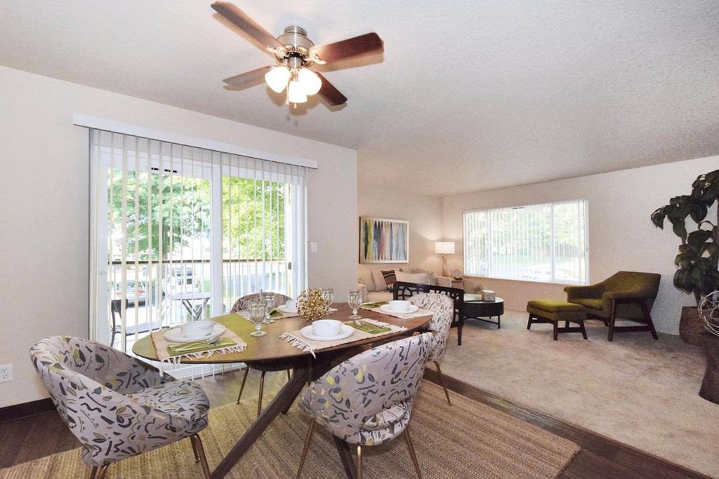 a dining room with a table and chairs and a ceiling fan