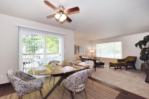 a dining room with a table and chairs and a ceiling fan