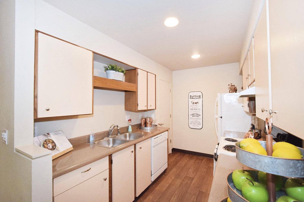 a kitchen with white cabinets and a wooden floor