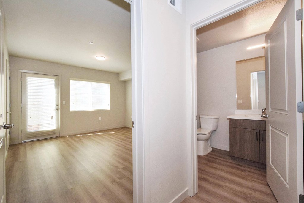 a bedroom with a toilet a sink and a mirror