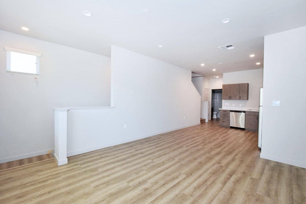 an empty living room with white walls and hardwood floors