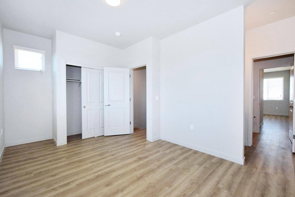 an empty living room with white walls and hardwood floors