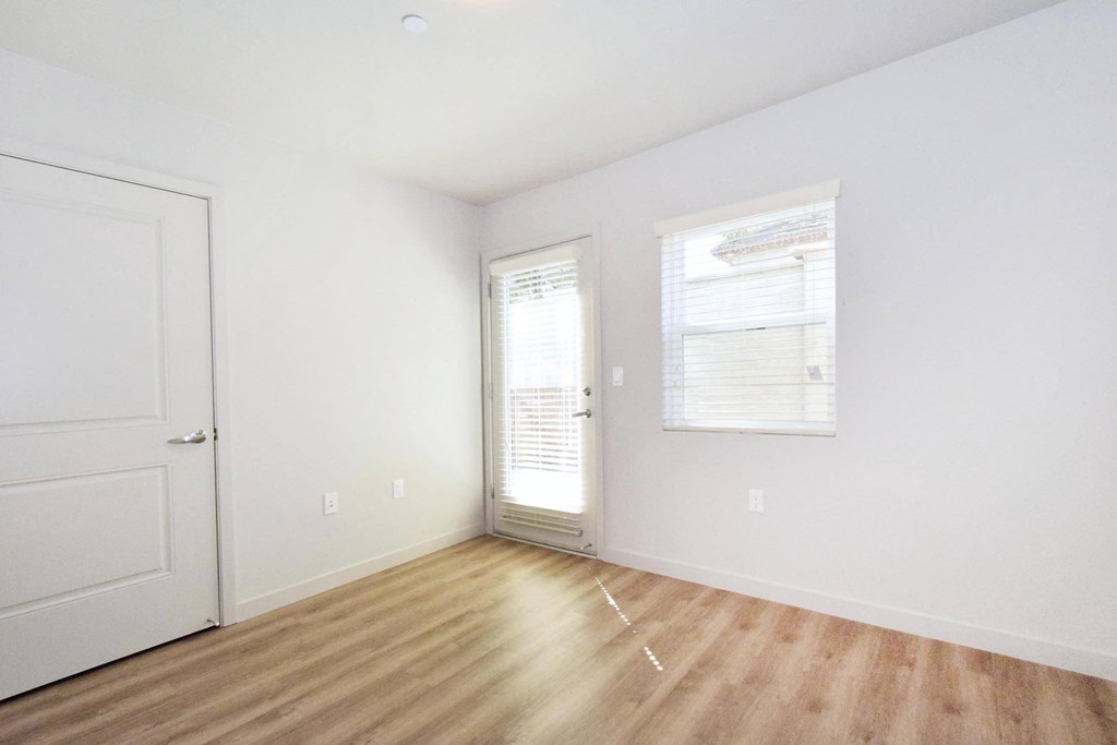 a bedroom with hardwood floors and white walls