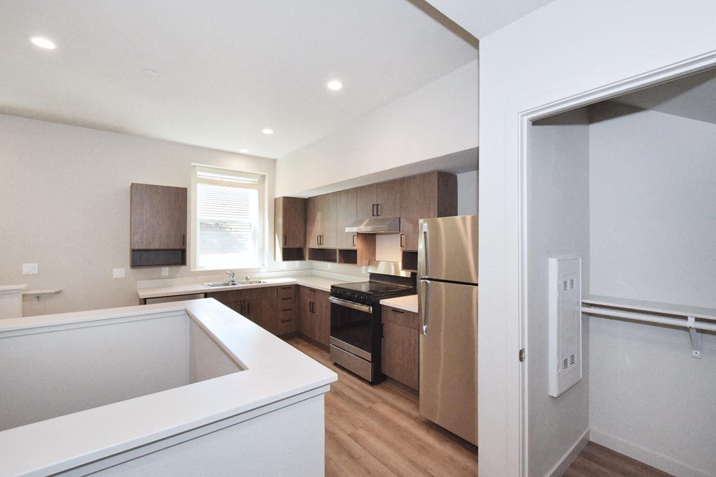 a kitchen with wood floors and white walls