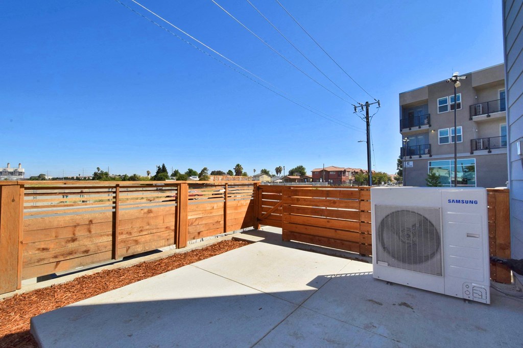 a washer and dryer sit on a patio next to an apartment building