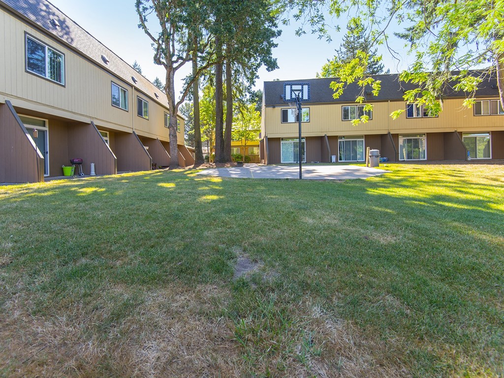 the backyard of a house with a green lawn and trees
