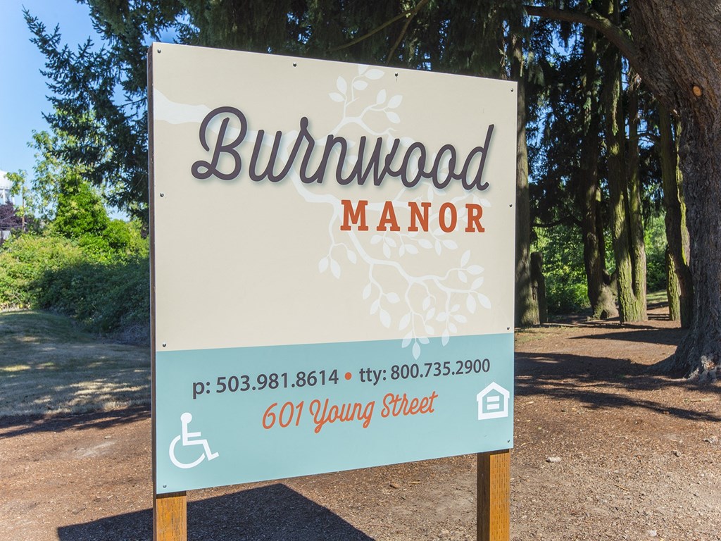 a sign that reads in front of trees
