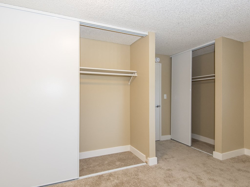 an empty bedroom with a closet and two closets