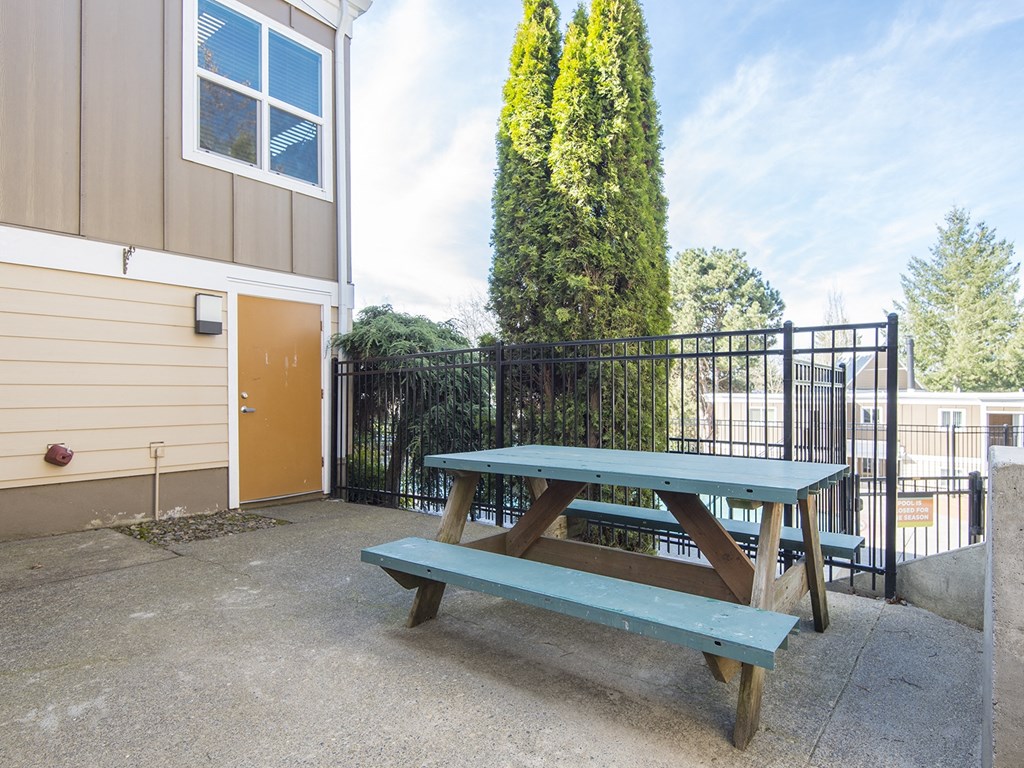 a picnic table with a bench in front of a building