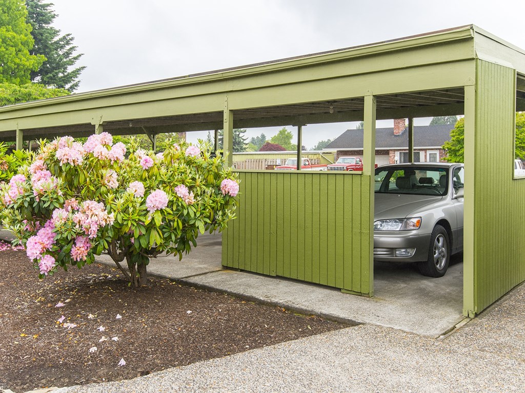 a green garage with a car parked in front of it