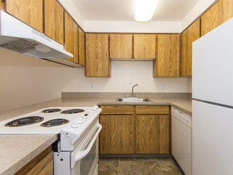 a kitchen with white appliances and wooden cabinets and a sink