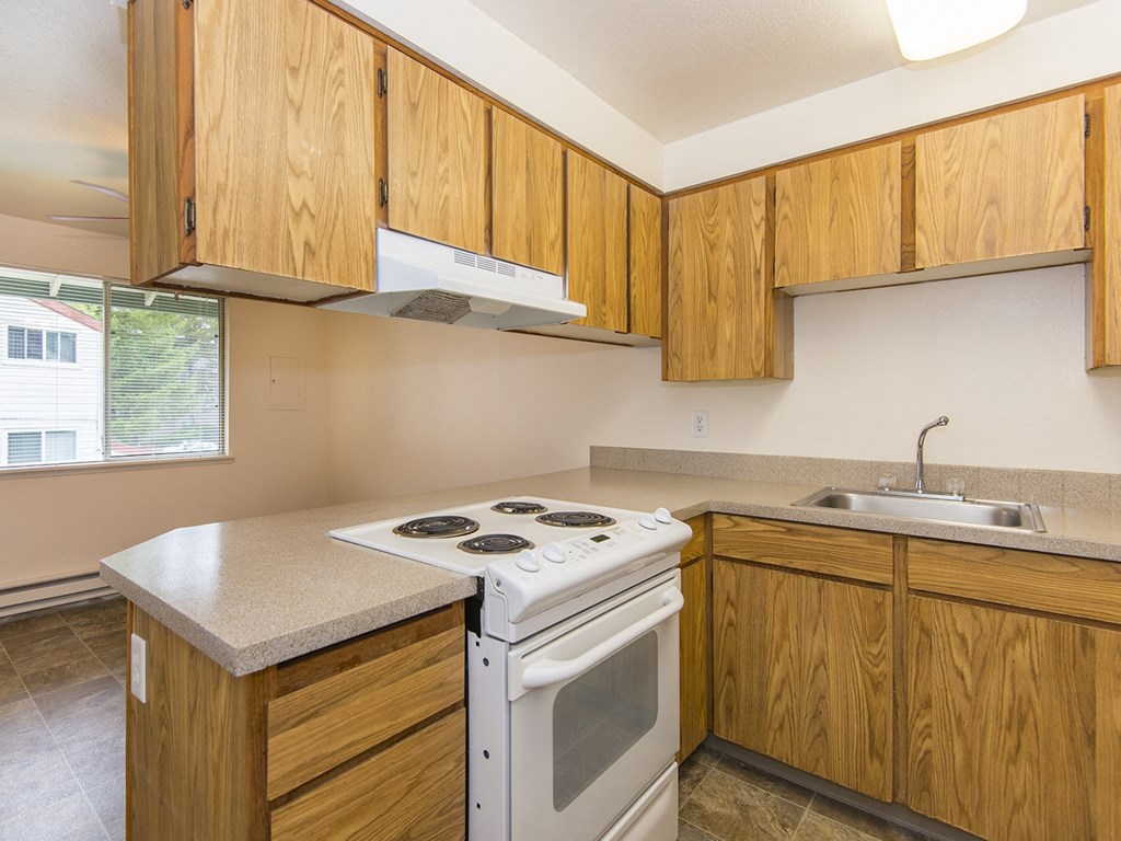 Willow Creek:  a kitchen with wooden cabinets and a white stove top oven