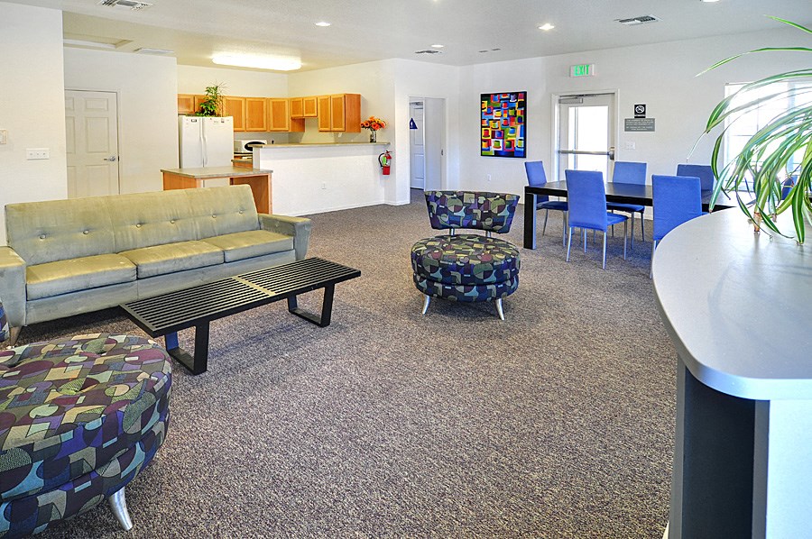 a living room with couches and chairs and a kitchen