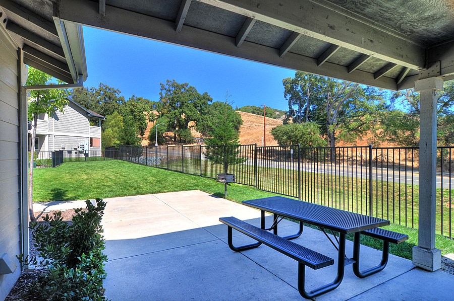 a picnic table on a patio in front of a fence