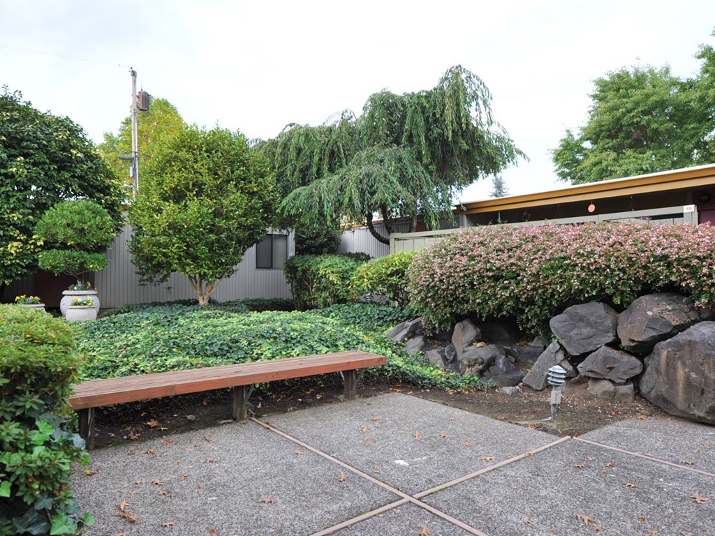 a bench in a garden in front of a house
