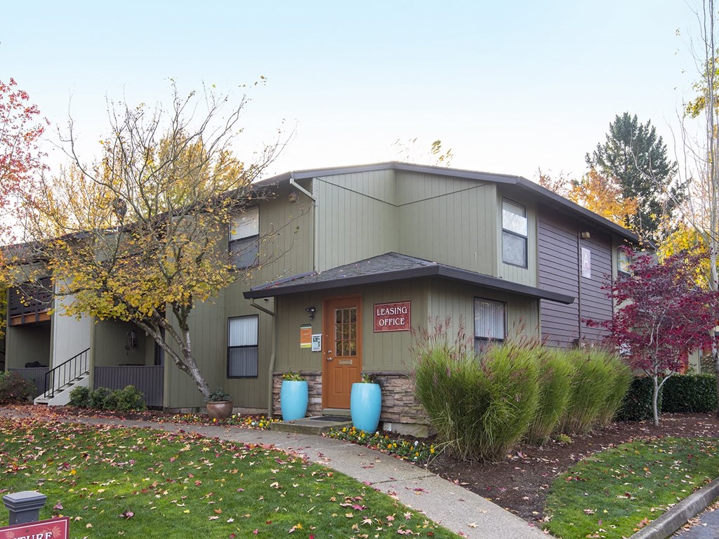 a gray house with a brown roof and a orange door