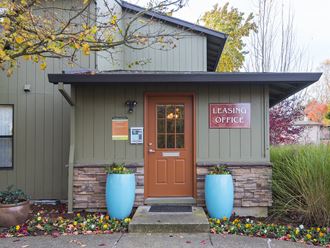 a small building with a orange door and a sign that reads leasing office