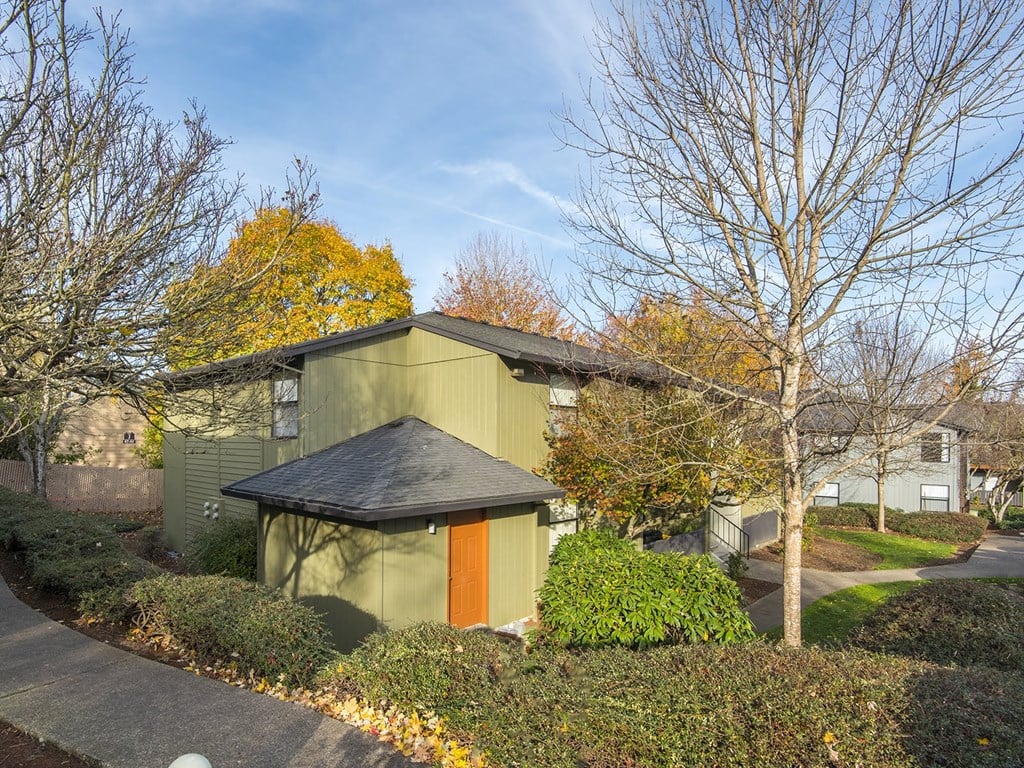a home with a green exterior and orange door