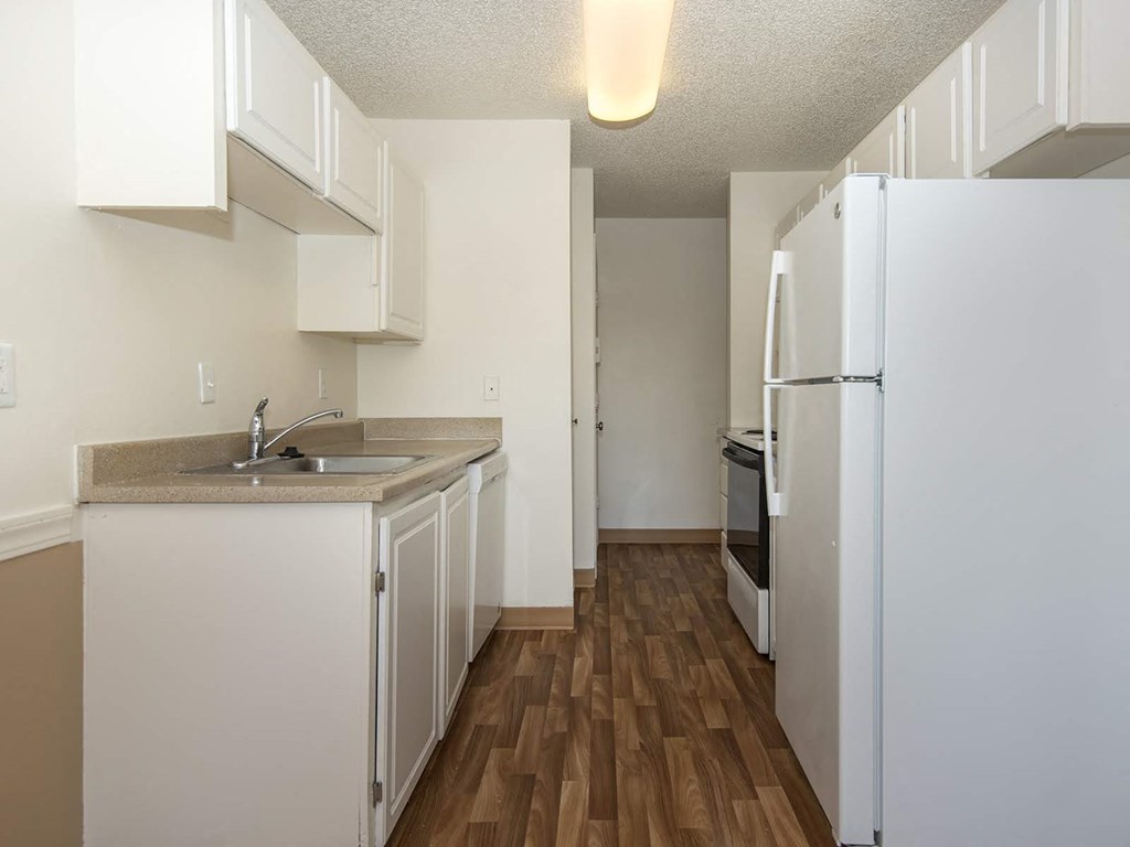 a kitchen with white cabinets and a white refrigerator