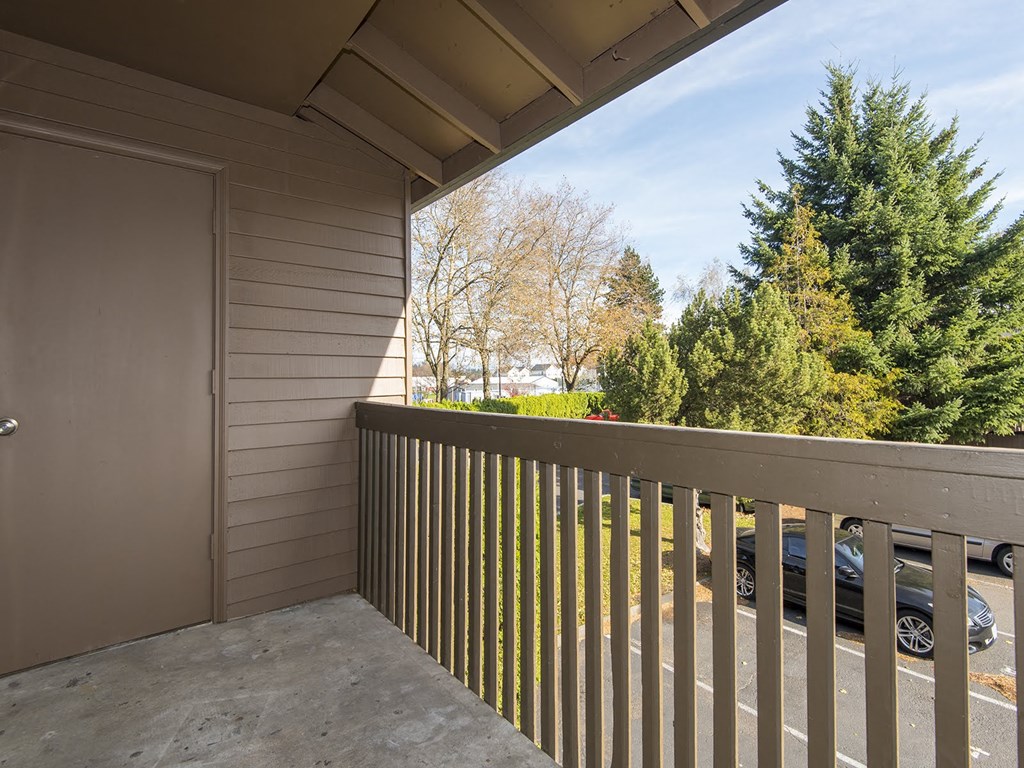the view from the balcony of a house with a car parking lot