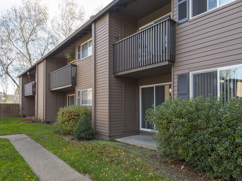 the exterior of an apartment building with a sidewalk
