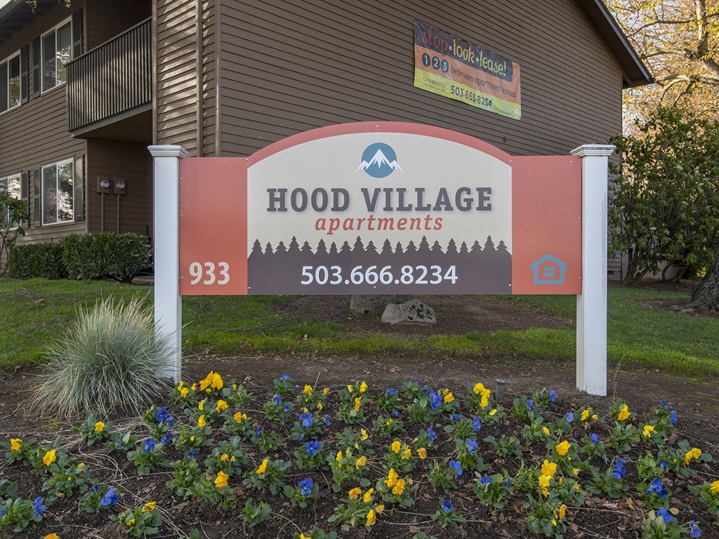a sign in front of a building that reads flood village apartments