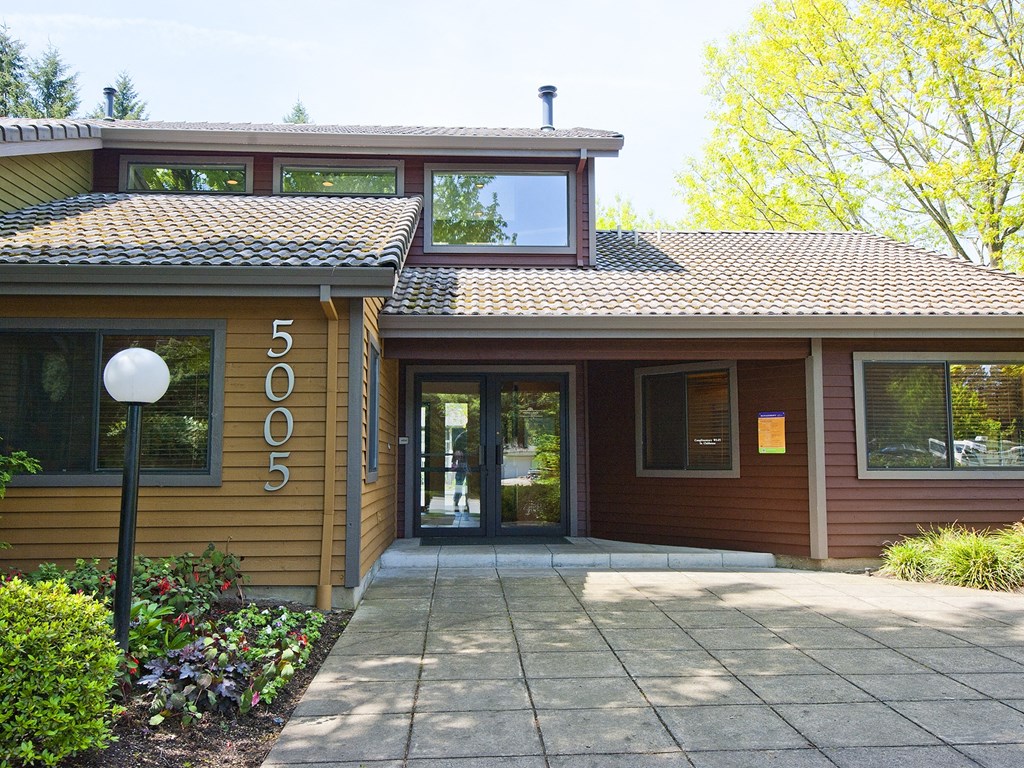 a picture of the front of a brown building with a walkway in front of it