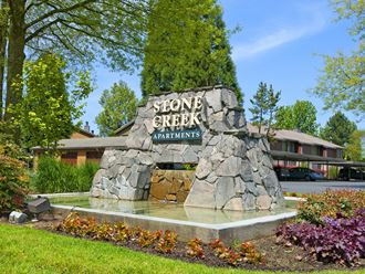 stone creek apartments sign in front of a building