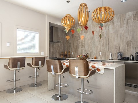 a modern kitchen with a long counter and bar stools
