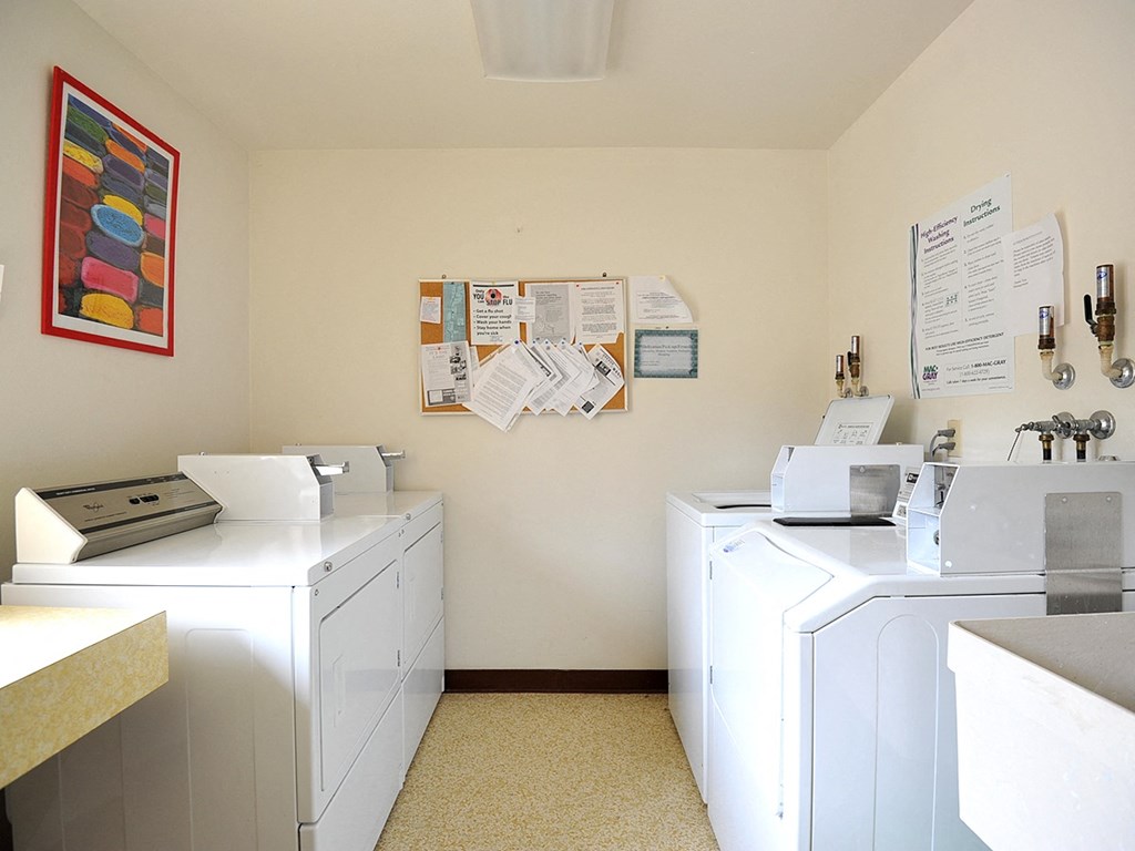 a laundry room with washers and dryers and a poster on the wall