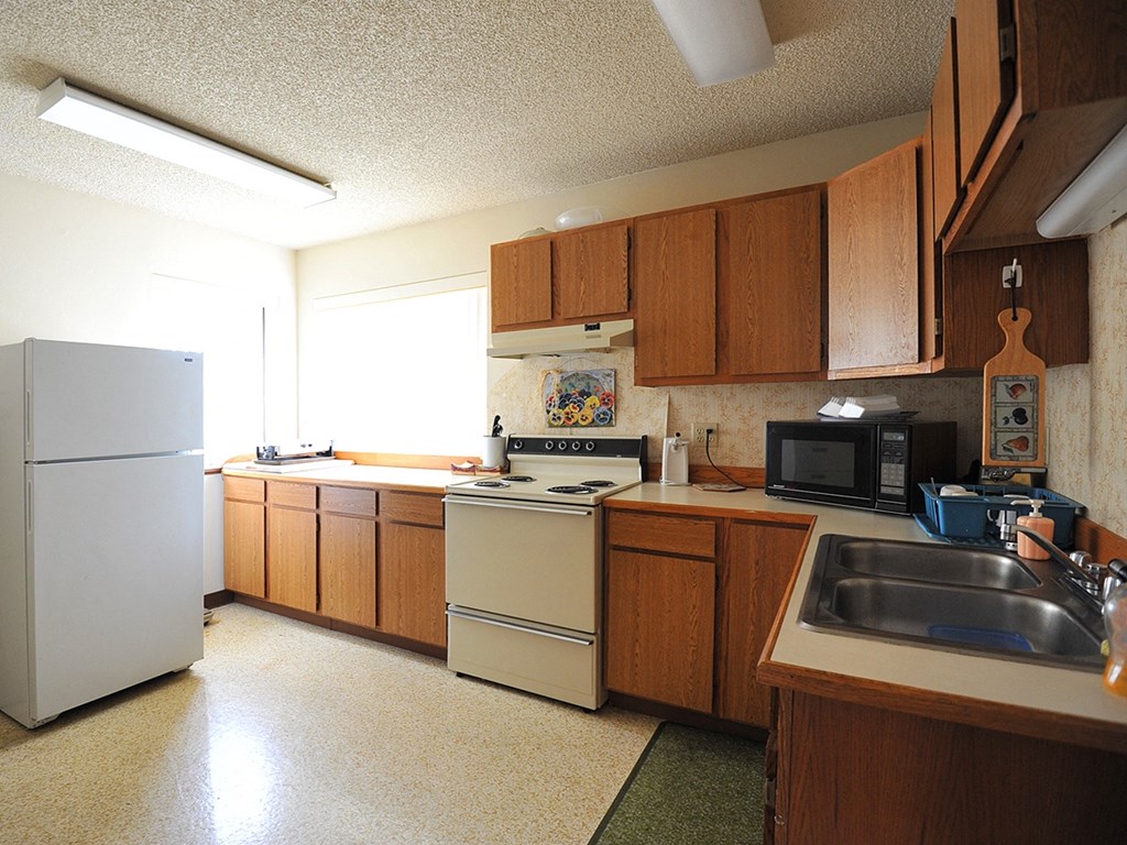 a kitchen with white appliances and wooden cabinets