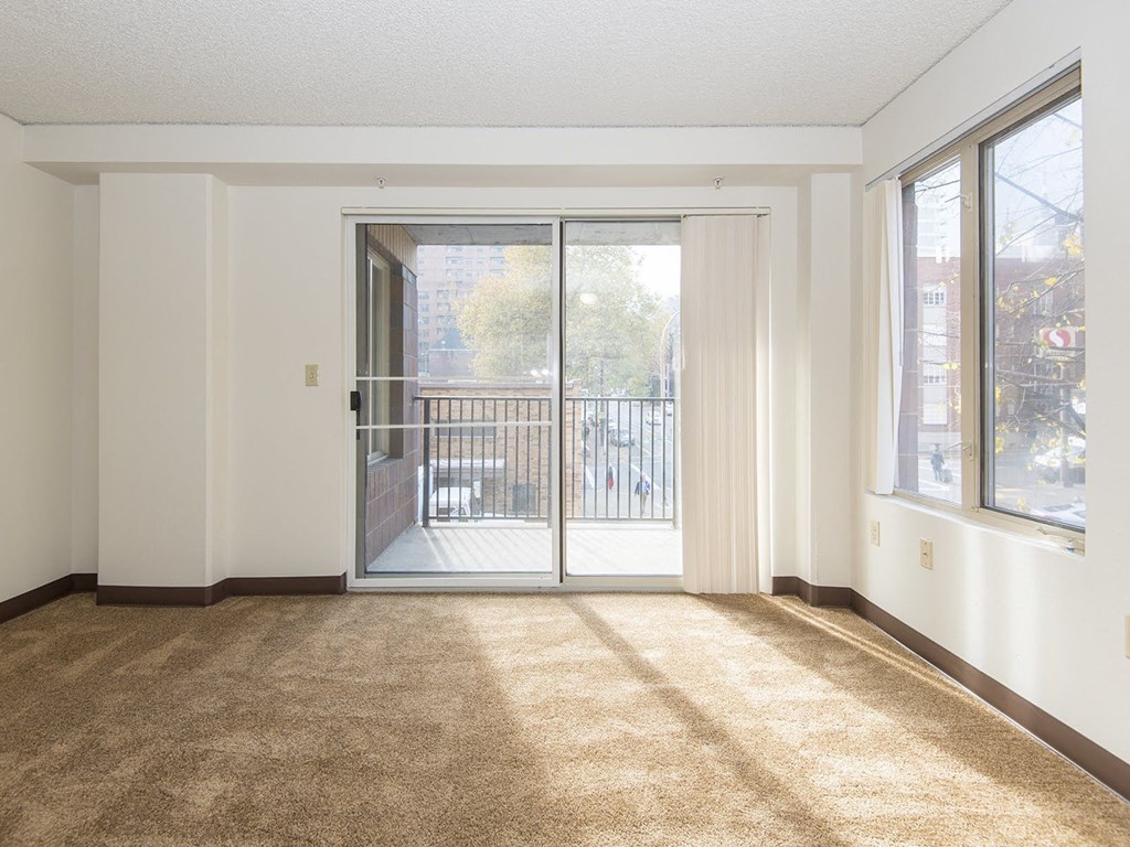 an empty living room with a door to a balcony