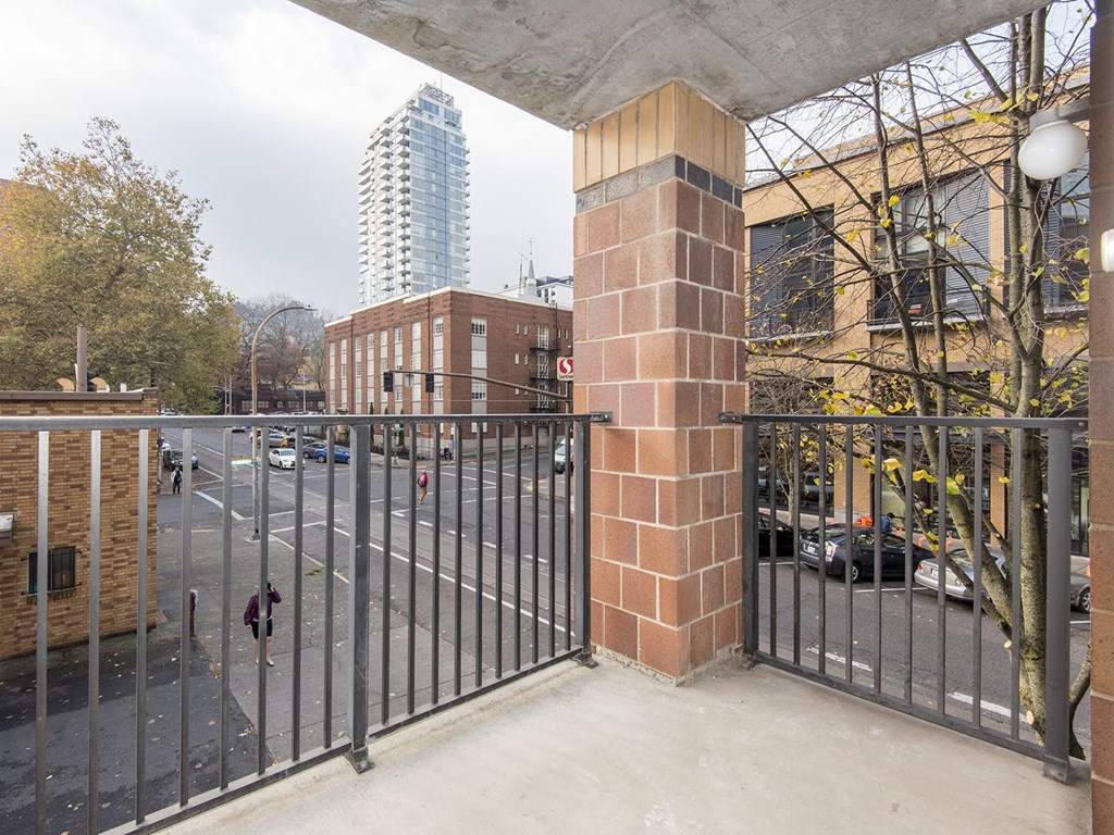 the view of a city street from a balcony with a gate