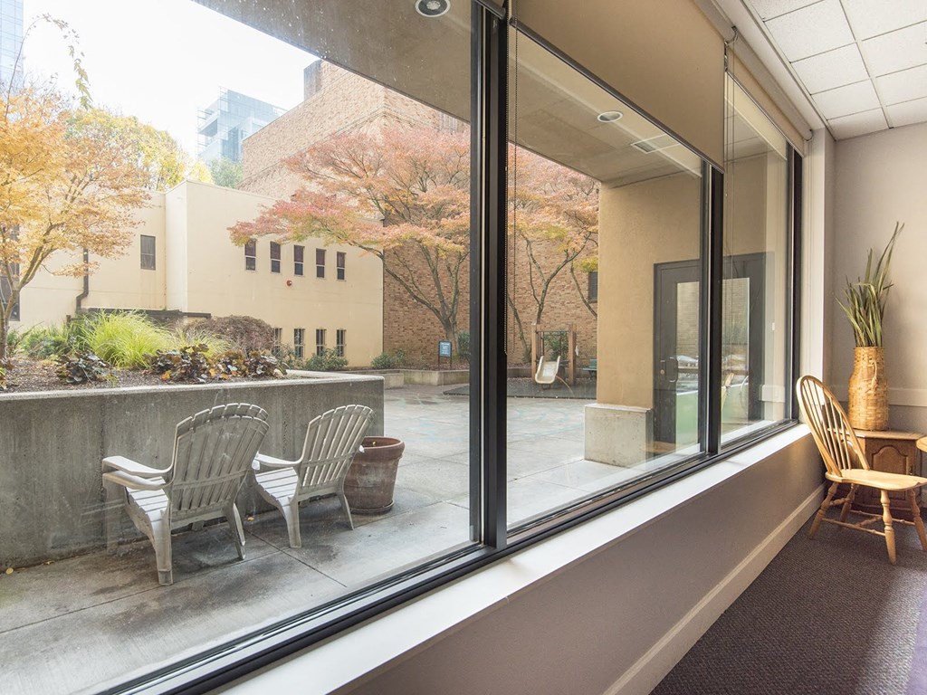 a patio with chairs and a table in front of a window