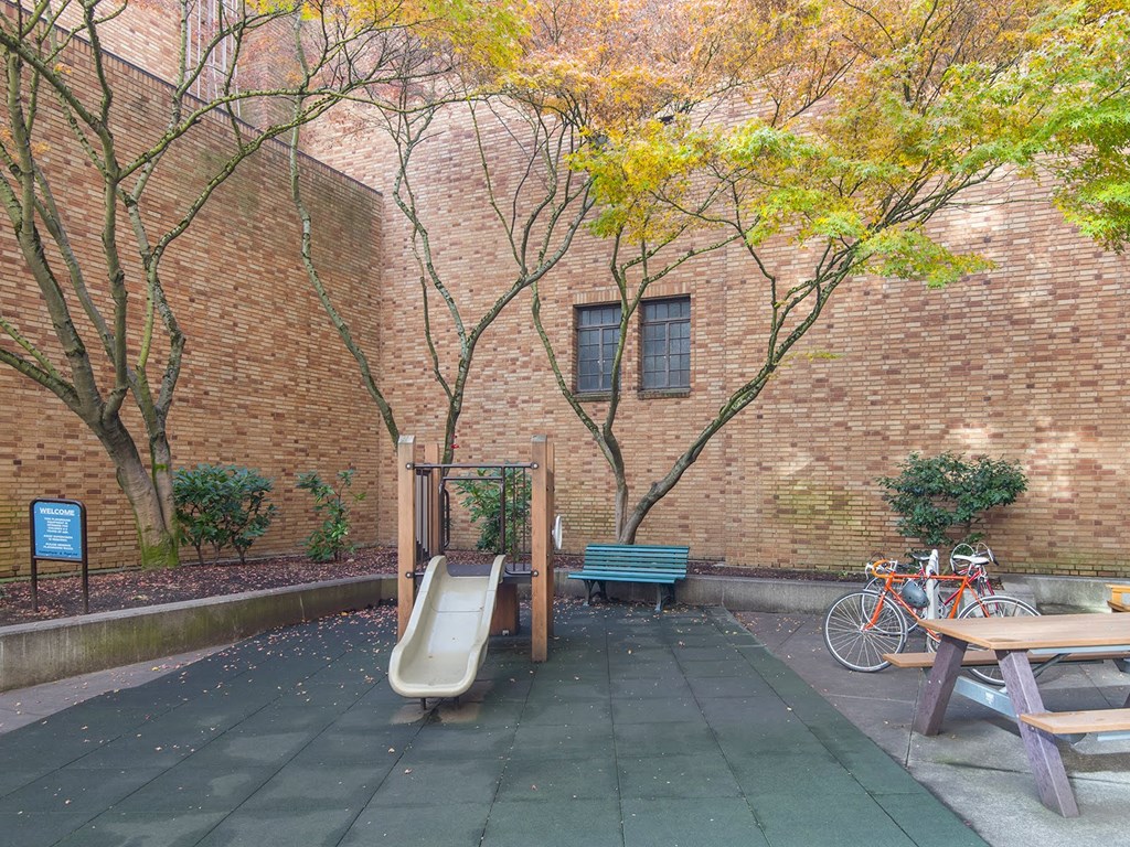 a childrens slide in front of a brick building