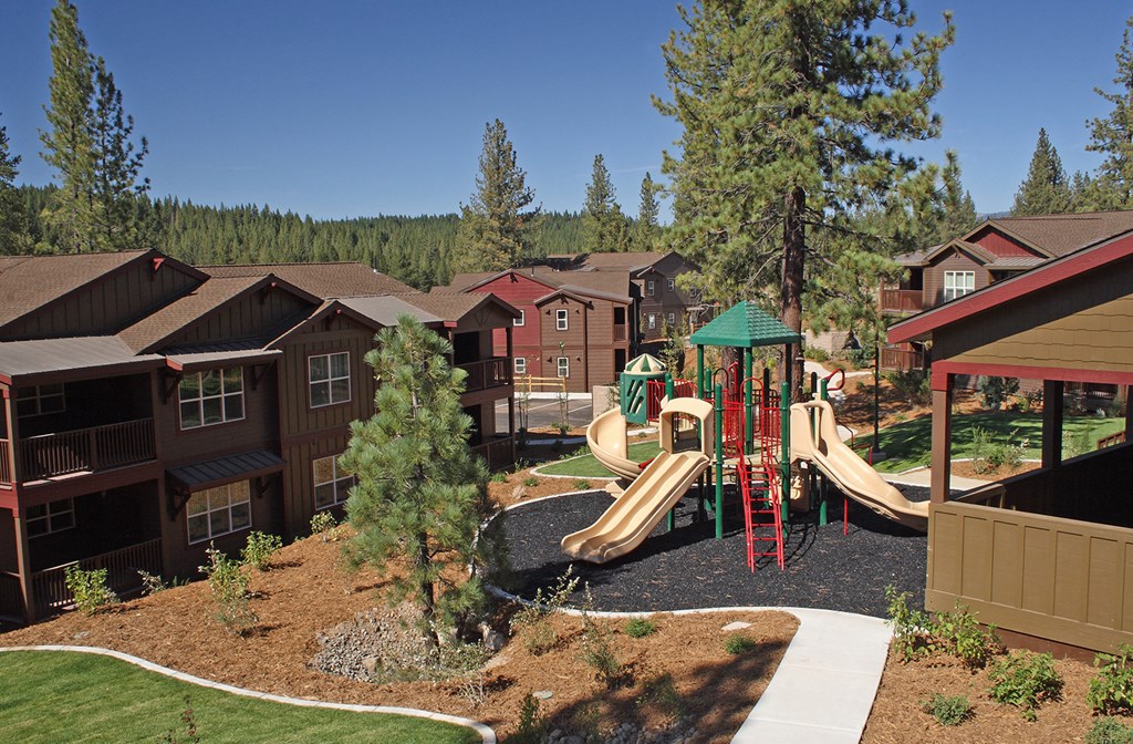 an aerial view of a playground with condos in the background