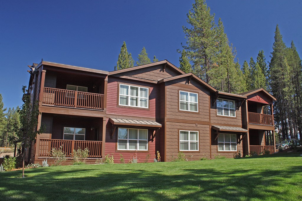 a large brown house with trees in the background