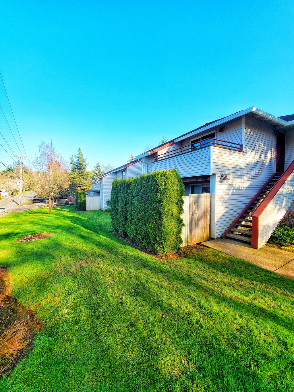 the side of a house with a yard and a staircase