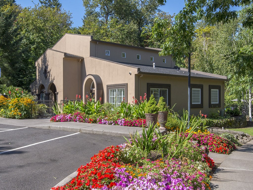 a house with a garden of flowers in front of it