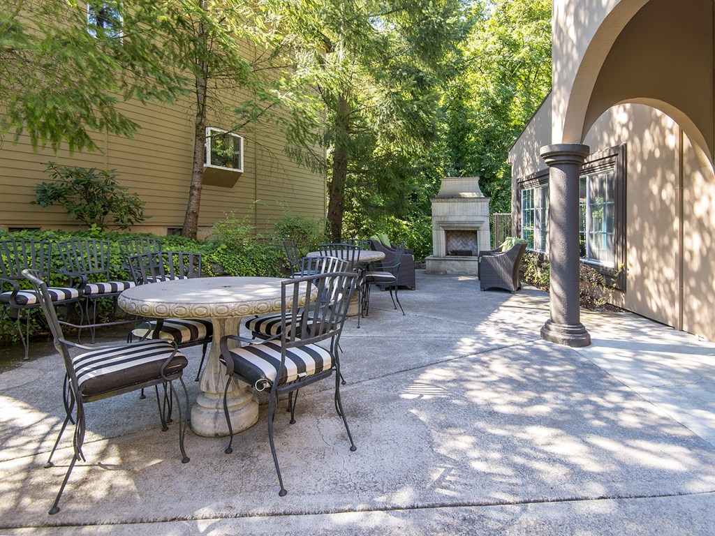 a patio with tables and chairs and a fireplace