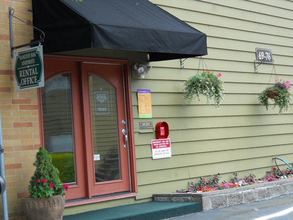 the front of a building with a red door and a sign that says rental office