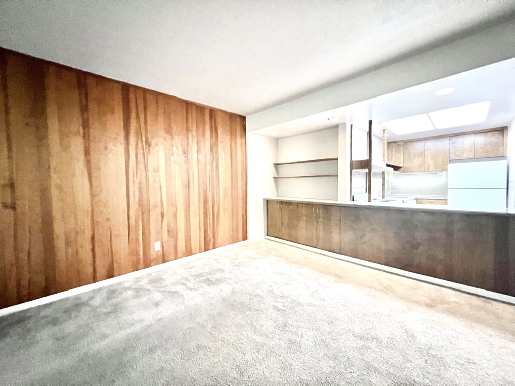 an empty room with wood paneled walls and a concrete floor