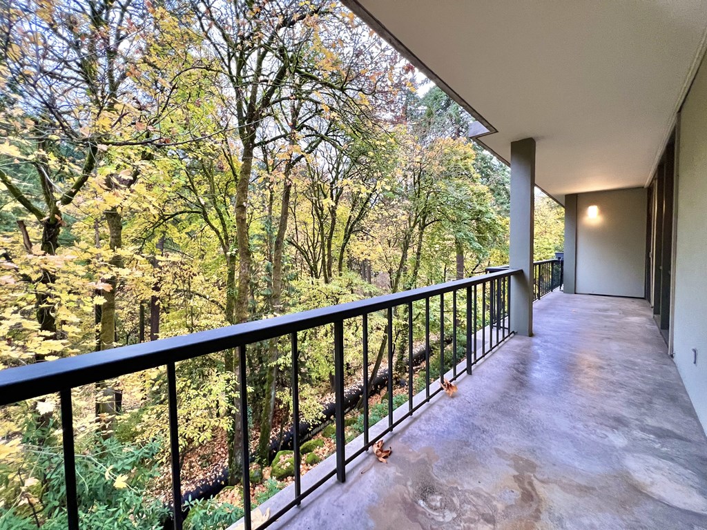 a balcony with a view of a wooded area and some trees