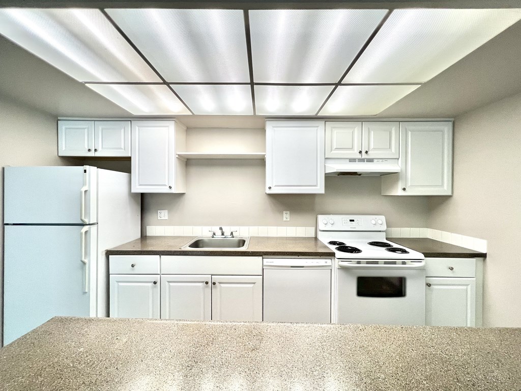 a white kitchen with white appliances and white cabinets