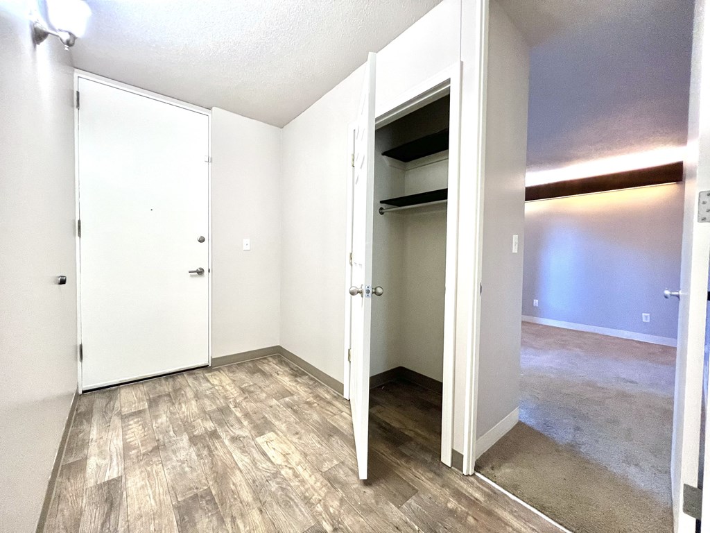 an empty room with a closet and a mirrored door