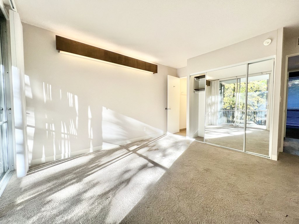 a living room with a glass door and a carpeted floor