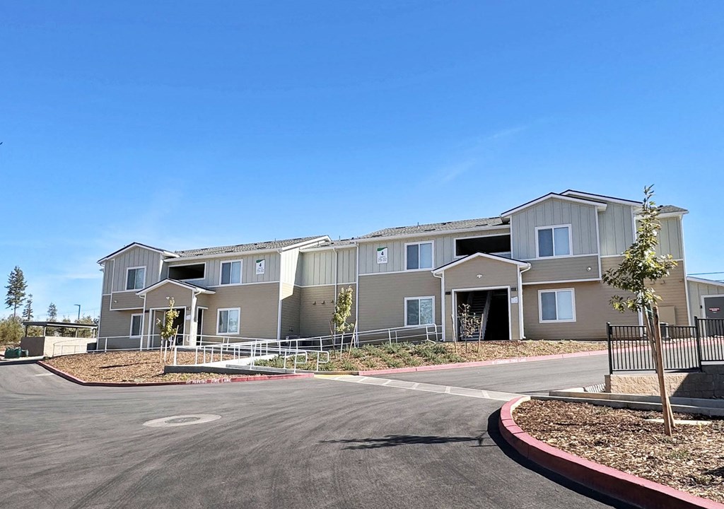 an exterior view of an apartment building with a parking lot
